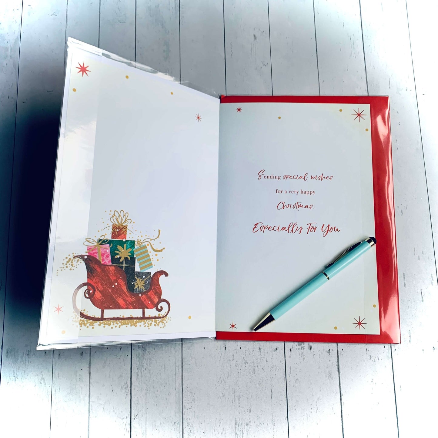 Inside view of 'Both of you' Christmas card, featuring small colourful sleigh filled with gifts in lower left corner. Wording says 'Sending special wishes for a very happy Christmas especially for you'. From Wickerhearts Christmas card and gift collection.