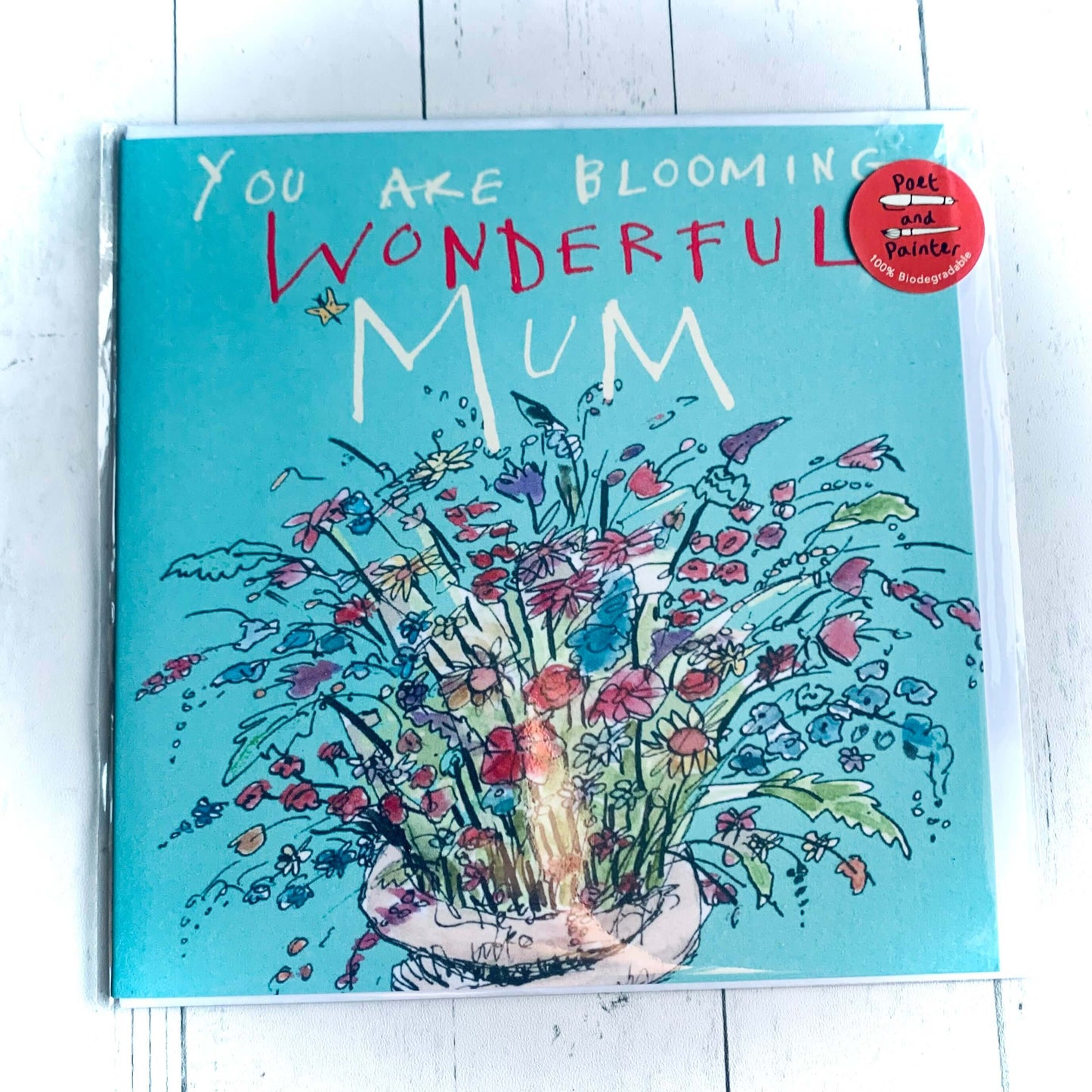 Light blue card with colourful spray of flowers decoration and the words 'You are blooming wonderful Mum'. From the Wickerhearts card Collection.