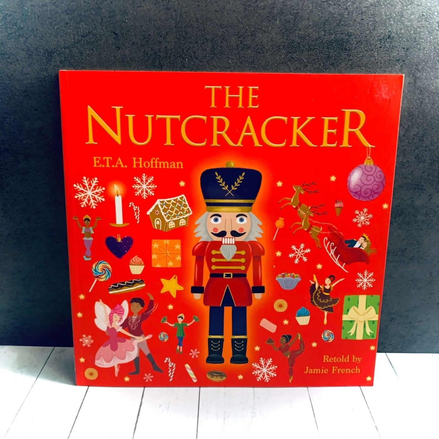 Brightly coloured illustrations of a Nutcracker and connected images on red background, from The Nutcracker Story book. From Wickerhearts Christmas gift collection.