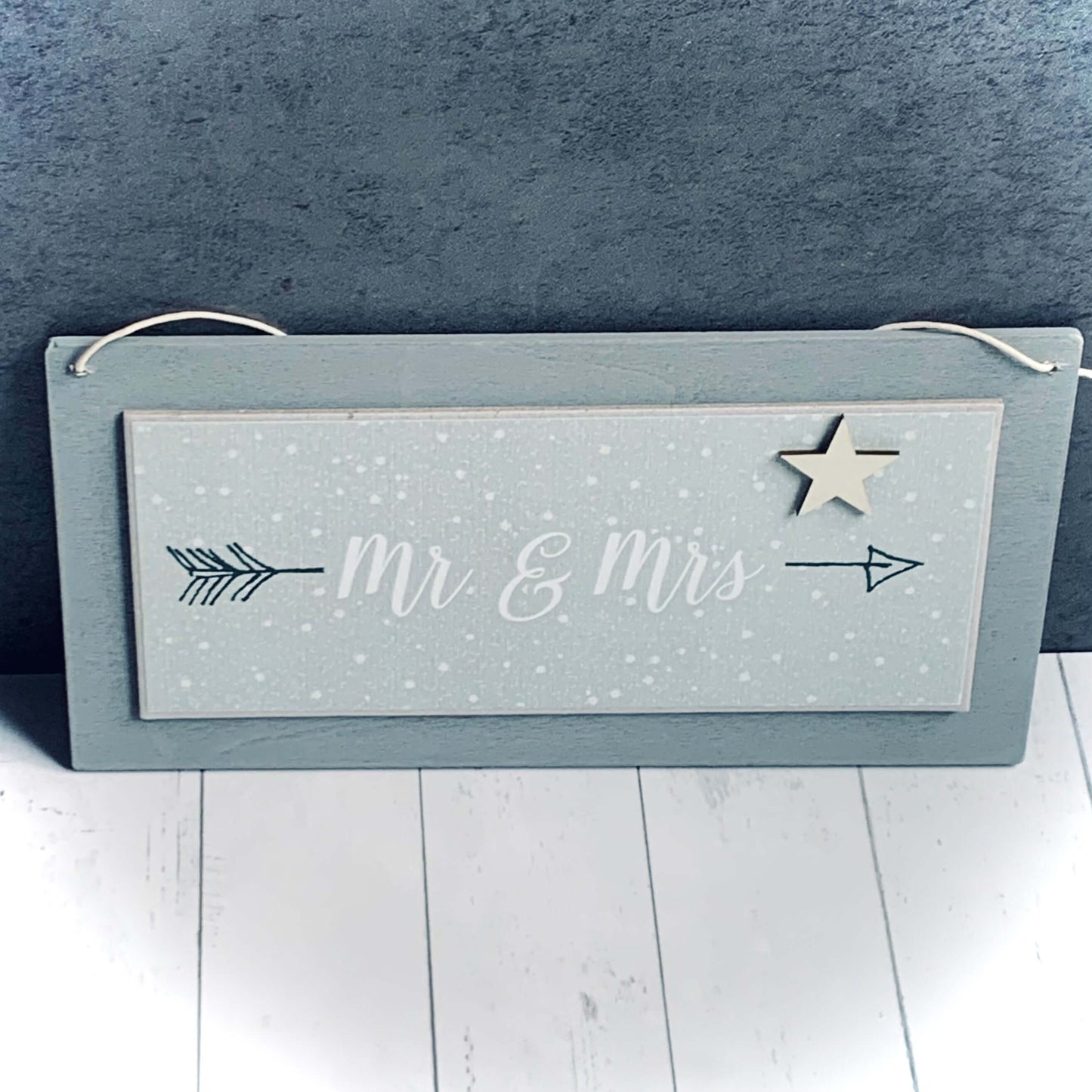 Light grey wood, horizontal hanging sign. With small wooden star and the words 'Mr and Mrs' between a black arrow. From Wickerhearts East of India gift collection.