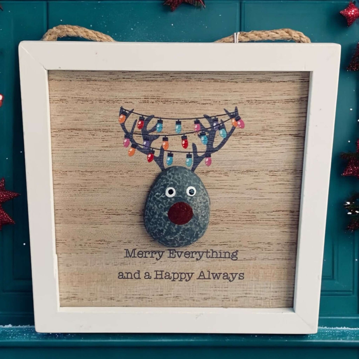 Small white framed picture of a pebble decorated Reindeer with festive lights on the antlers and the words 'Merry Everything and a Happy Always'. From Wickerhearts Christmas gift collection.