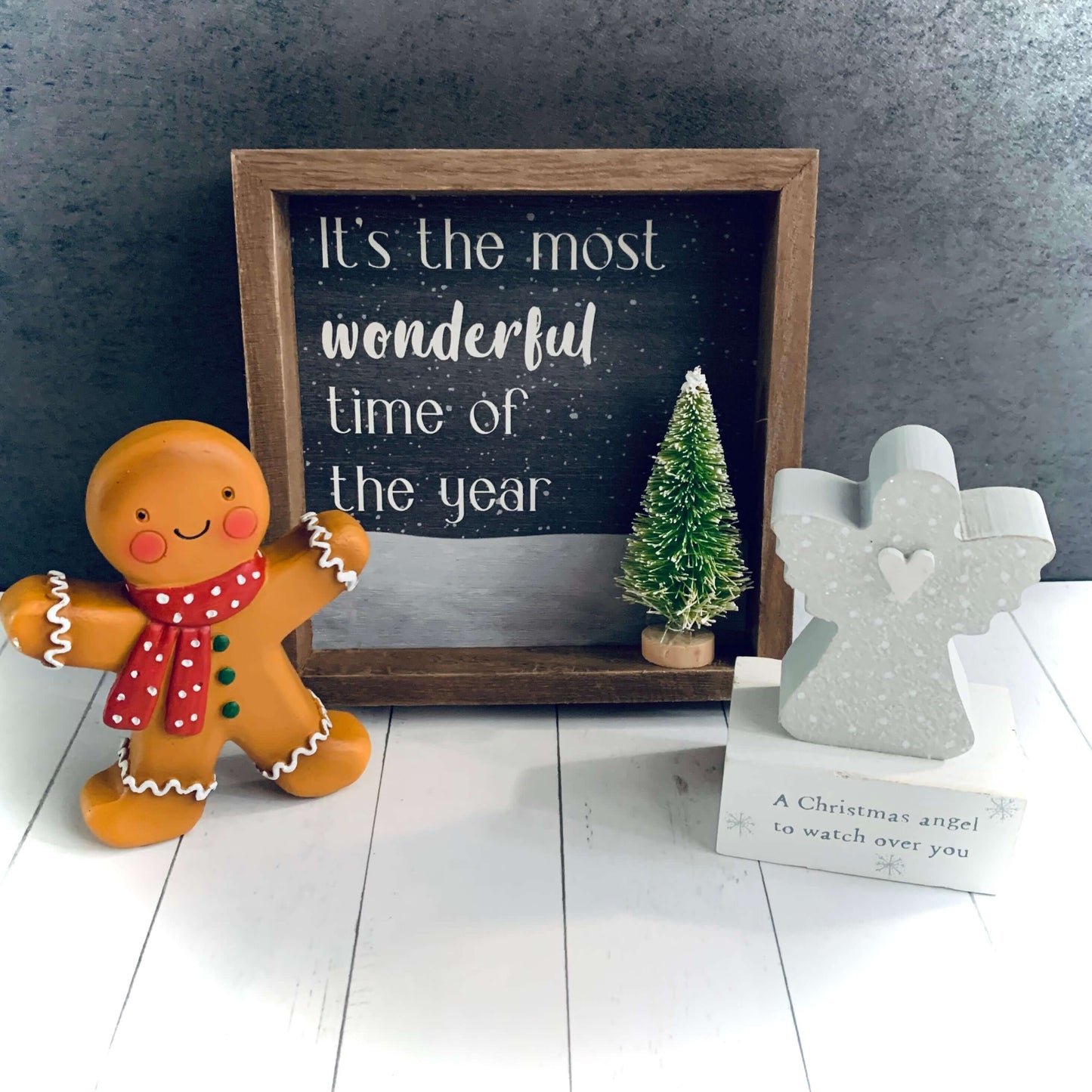Gingerbread man Christmas decoration next to a wooden picture of a Christmas Tree and a grey Christmas angel wooden block. All products from Wickerhearts Christmas gift collection.