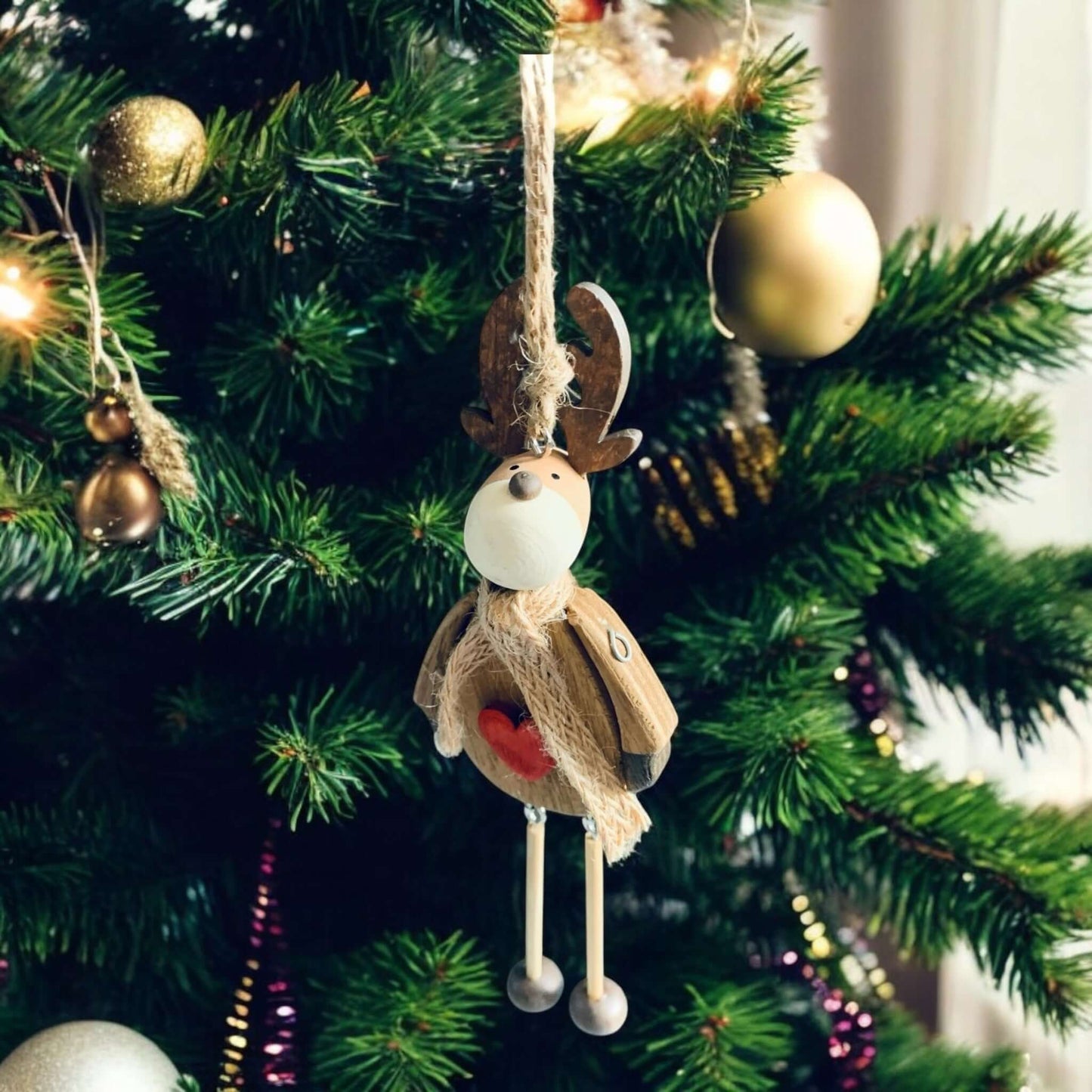 Wooden brown reindeer with scarf and dangling legs, hanging from a Christmas tree. From Wickerhearts Christmas gift collection.