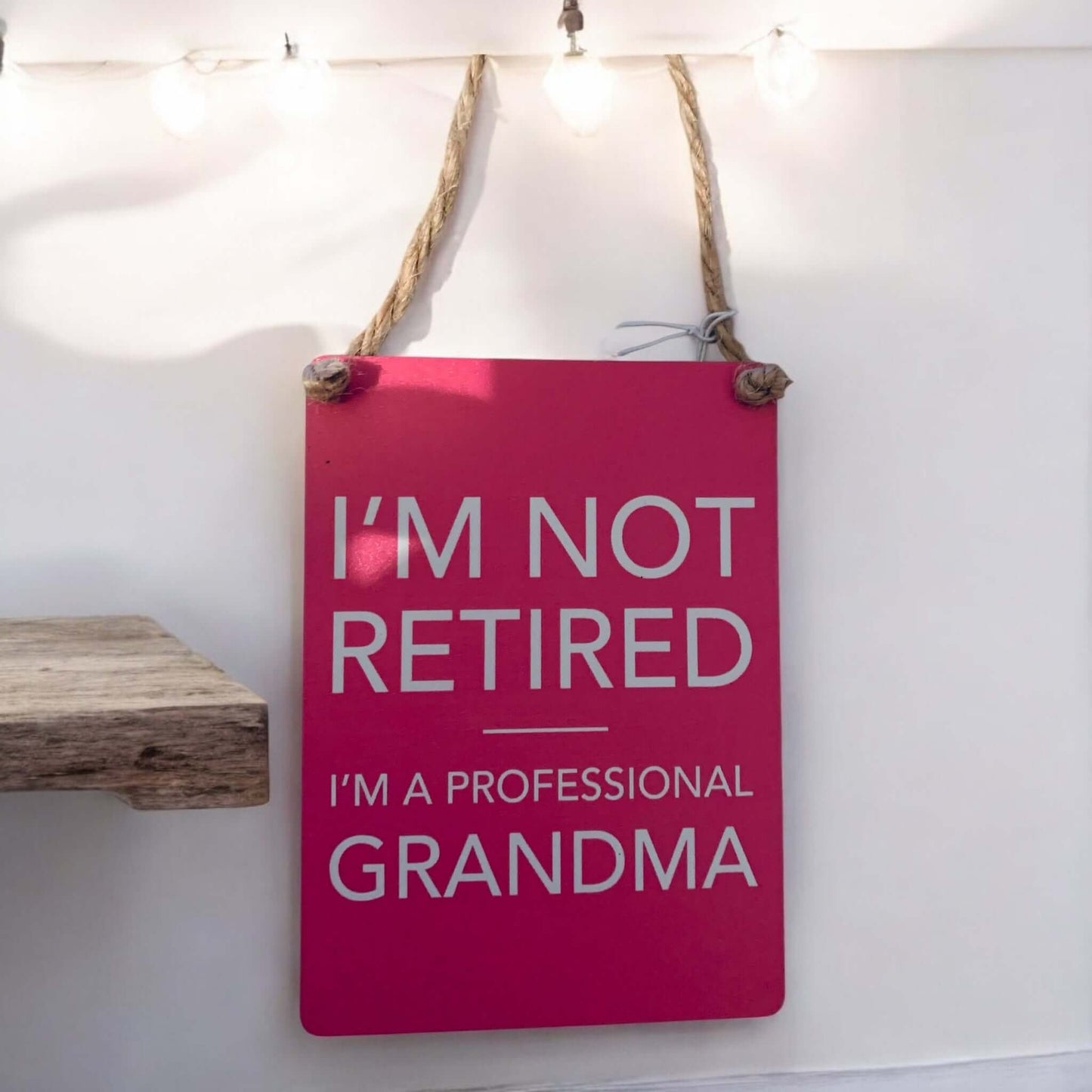 Pink metal mini sign saying 'I'm not retired I'm a professional Grandma', perfect for gifting or home decor.