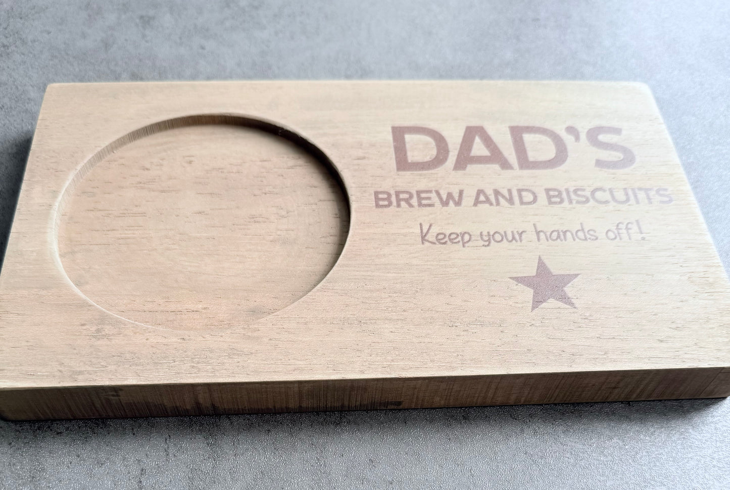 Wooden cutting board with engraved text on a gray surface