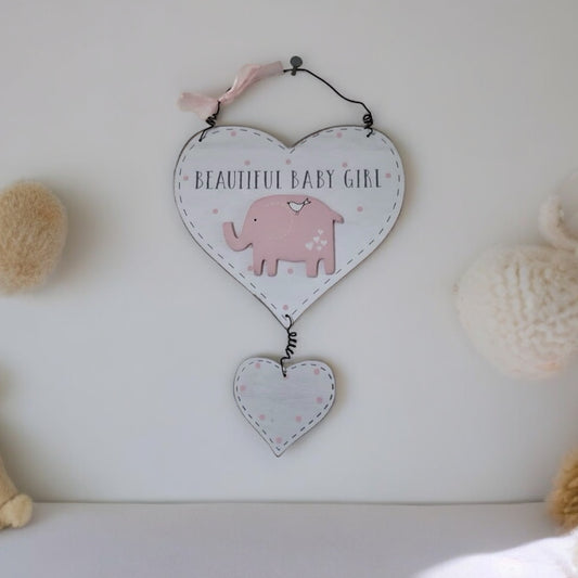 Hanging pink and white wooden heart saying Beautiful Baby Girl, with a pink elephant and a smaller pink and white heart attached below. Hangs on a nursery wall with wire and a small pink ribbon. From the Gift collection at Wickerhearts.