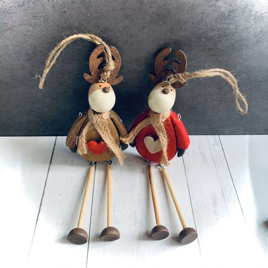 Hanging wooden reindeer with scarves in two different colours of brown and red. They have a heart on their front and moveable, dangly legs. From Wickerhearts Christmas gift collection.